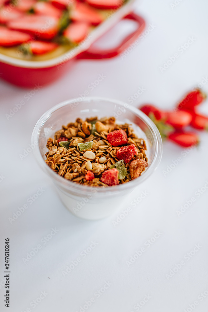 Strawberry cake and granola yogurt with red berry jam on the white backgound Strawberry cake and granola yogurt with red berry jam on the white backgound