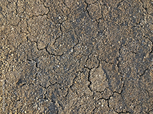 Cracked dry ground mud, dried under sun road.