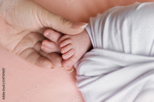newborn baby feet and mother hands