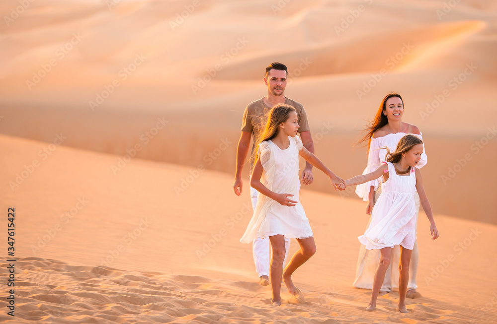 Young family of four in big sand desert