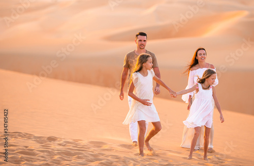 Young family of four in big sand desert