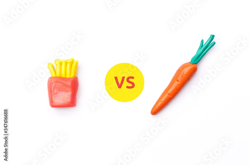 Healthy vs unhealthy food. French fries versus carrot on white isolated background with copy space. Flat lay  view from top. Healthy diet concept. Proper nutrition  healthy lifestyle  fast food.