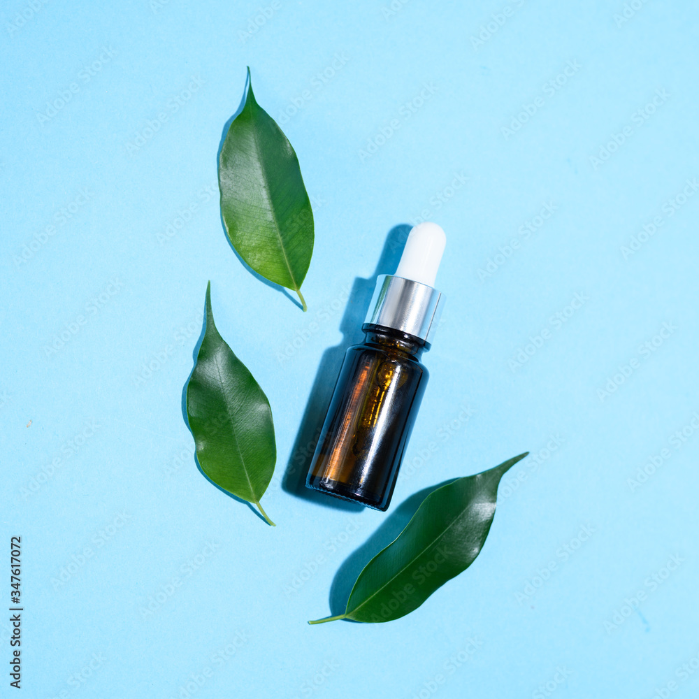 A glass dropper bottle on the blue background. A glass dropper bottle on the blue background.