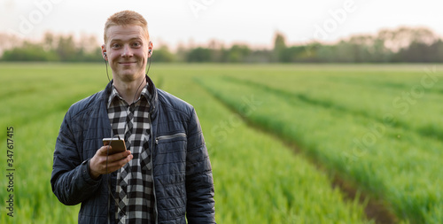 young man in the field smiling with phone