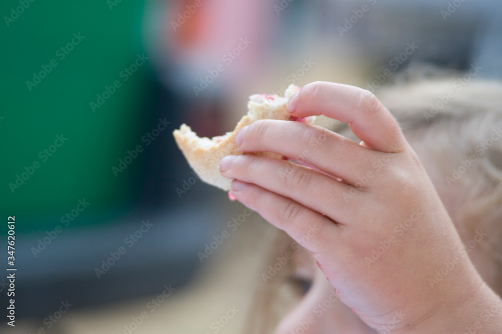 Hand mit angebissenem Brötchen in der Hand Hand mit angebissenem Brötchen in der Hand