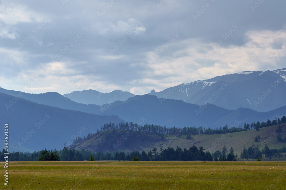 Obraz premium A green plain surrounded by high hills.