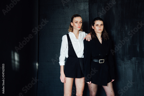 Two beautiful fashionable women stand next to brunette and blonde