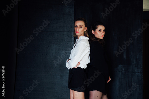 Two beautiful fashionable women stand next to brunette and blonde