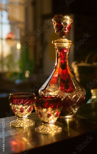 Table set for drinking alcohol. Soviet carafe for vodka and two glasses. Sunset light. Home still life.