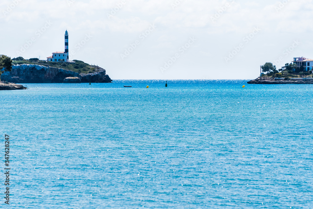 View of the port and the lighthouse with blue sky, Portocolom, Mallorca