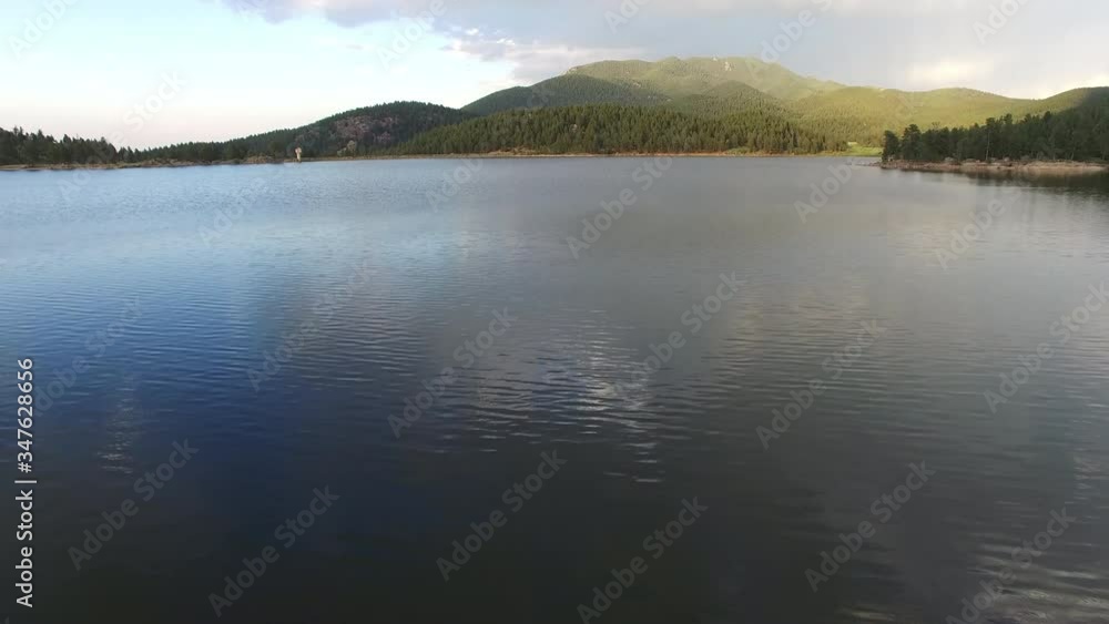 Aerial view of man paddleboarding in lake during weekend, scenic view of forest and mountains against sky - Lake Wellington, Colorado Aerial view of man paddleboarding in lake during weekend, scenic view of forest and mountains against sky - Lake Wellington, Colorado