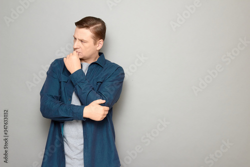 Portrait of thoughtful focused man touching lips with finger