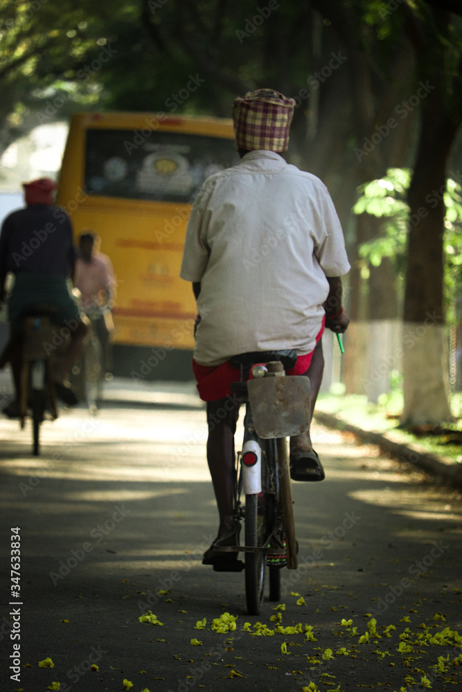 An old village man going for work on a bicycle in the morning An old village man going for work on a bicycle in the morning
