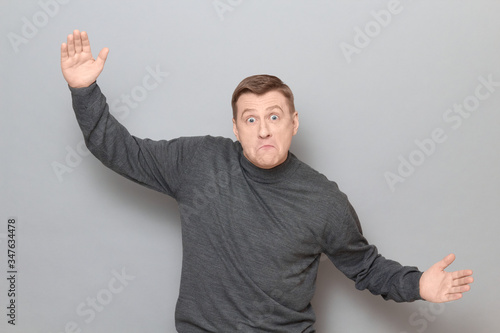 Portrait of shocked amazed mature man showing large size of something