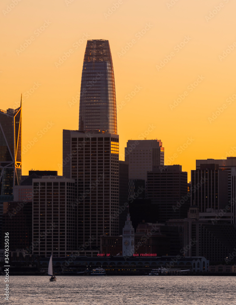 Downtown San Francisco, Ca. business district at sunset with boat on the water in the bay Downtown San Francisco, Ca. business district at sunset with boat on the water in the bay
