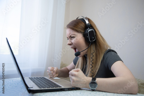 Angry business woman screaming and talking during online video conference on laptop computer
