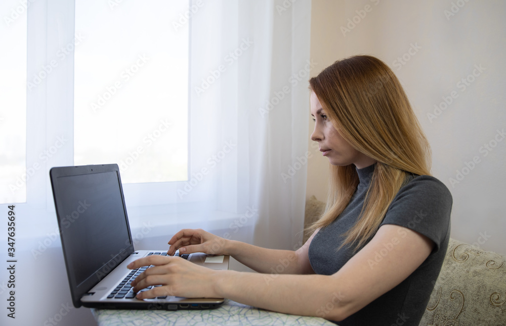 young american teen girl wear headphones video calling on laptop. pretty woman student looking at computer screen watching webinar or doing video chat by webcam. young american teen girl wear headphones video calling on laptop. pretty woman student looking at computer screen watching webinar or doing video chat by webcam.