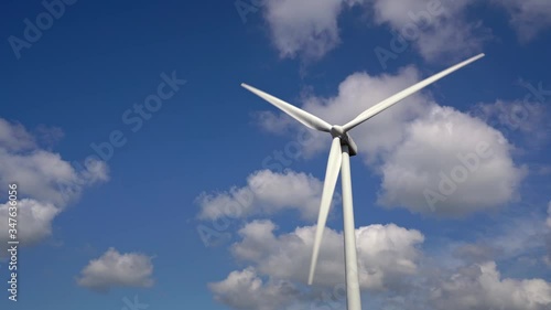 Hi resolution footage of wind turbine spinning against a blue sky with white fluffy white clouds, Ovenden Mooor, Halifax, west yorkshire, uk photo