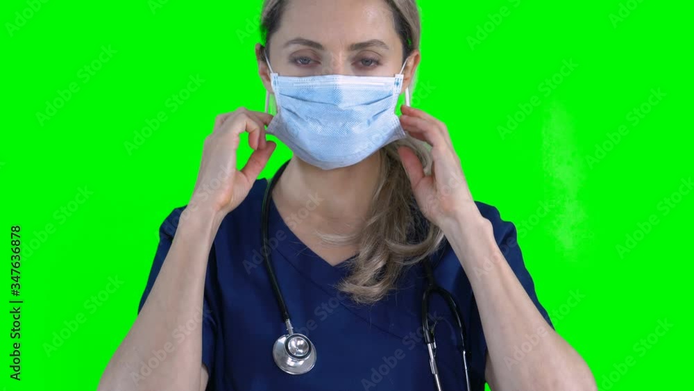 4K Portrait of female nurse doctor on green screen isolated with chroma key. Woman puts on surgical face mask standing looking at camera
4K Portrait of female nurse doctor on green screen isolated with chroma key. Woman puts on surgical face mask standing looking at camera