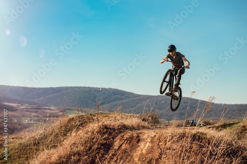 Dirt bike rider jumping in bike park on mountain bike