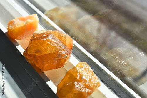 Canvastavla An image of three honey calcite crystals recharging on a sunny window ledge