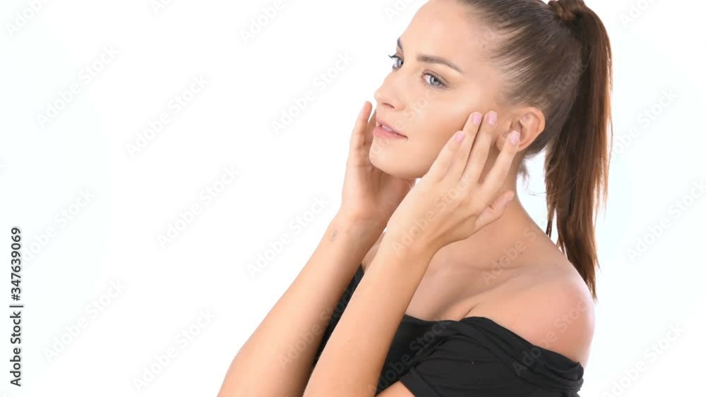 Beauty concept. A young woman is fondling a face on a white background. 4k Resolution. Beauty concept. A young woman is fondling a face on a white background. 4k Resolution.