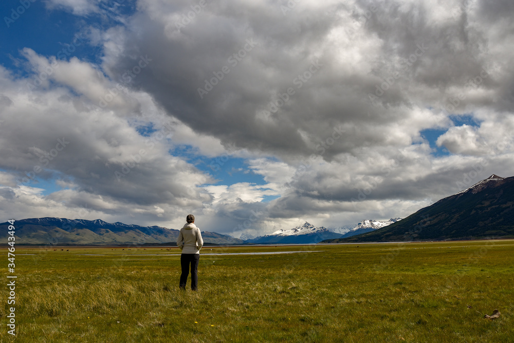 Female tourist enjoying the wide patagonian landscape with andes mountains and a lake