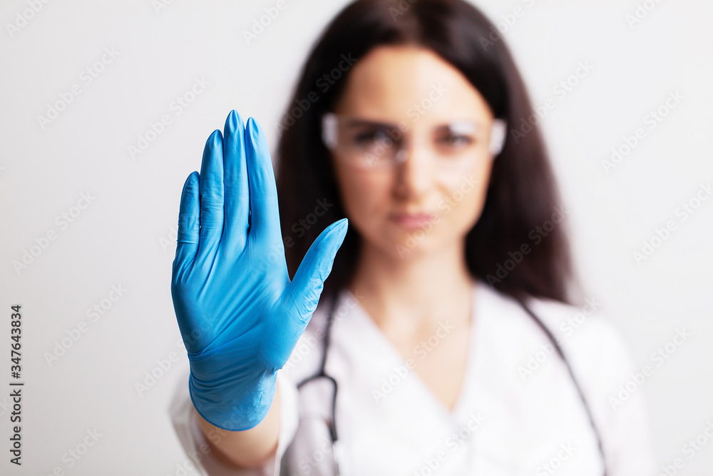 Female doctor in white coat shows hand stop Female doctor in white coat shows hand stop