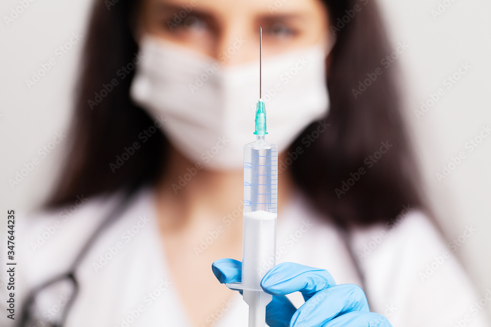Female doctor in gloves holds a syringe with vaccine Female doctor in gloves holds a syringe with vaccine