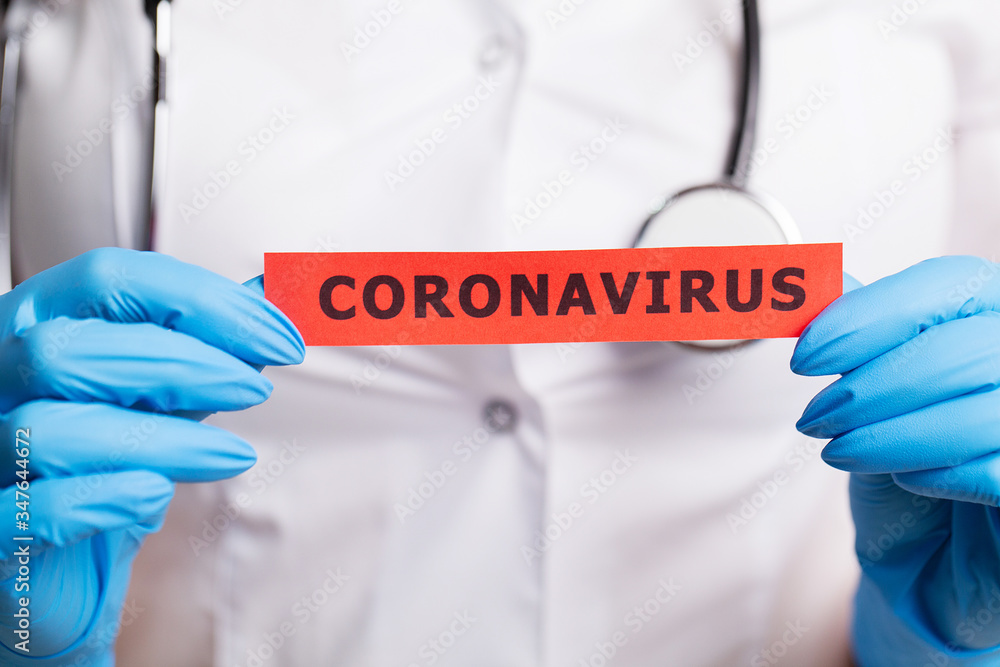 Female doctor in a white coat holding the inscription coronavirus Female doctor in a white coat holding the inscription coronavirus