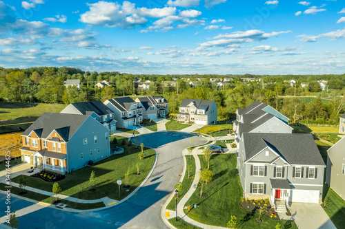 Aerial view of dead end street with residential single family luxury homes in the East Coast USA with blue cloudy sky