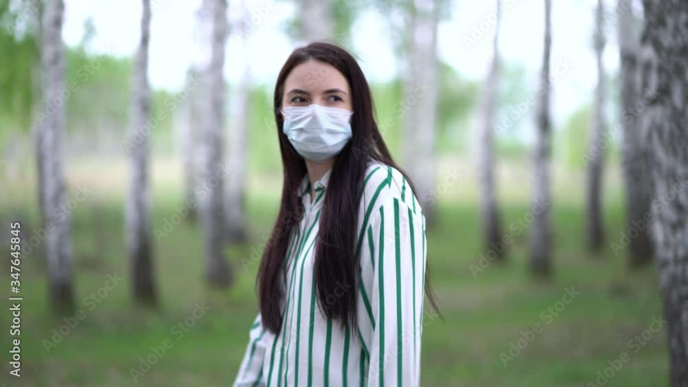 Stylish woman in a medical mask on a walk in the birch forest. Stylish woman in a medical mask on a walk in the birch forest.