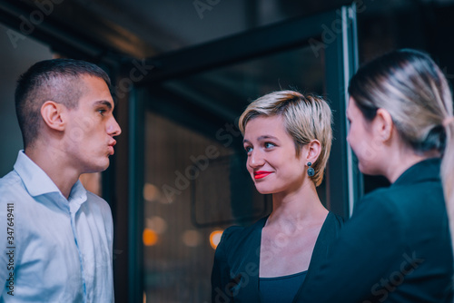 Group of three young entrepreneurs discussing business ideas in front of an office.