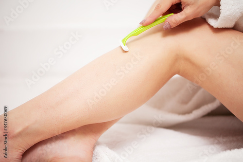 Woman doing hair removal at home in bathroom