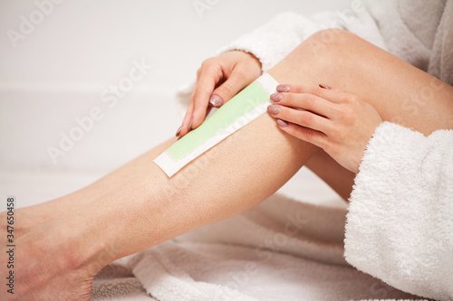 Woman doing hair removal at home in bathroom