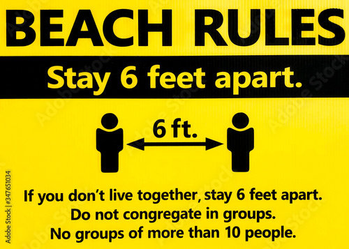 Beach rules sign. COVID-19 or coronavirus warning sign. Stay 6 feet apart. If you don't live together, stay 6 feet apart. Do not congregate in groups. No groups of more than 10 people. 