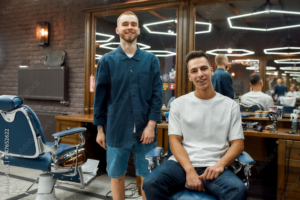 © Svitlana - Fashionable hairstyle. Portrait of cheerful barber and his young client looking at camera and smiling. In barbershop © Svitlana - Fashionable hairstyle. Portrait of cheerful barber and his young client looking at camera and smiling. In barbershop