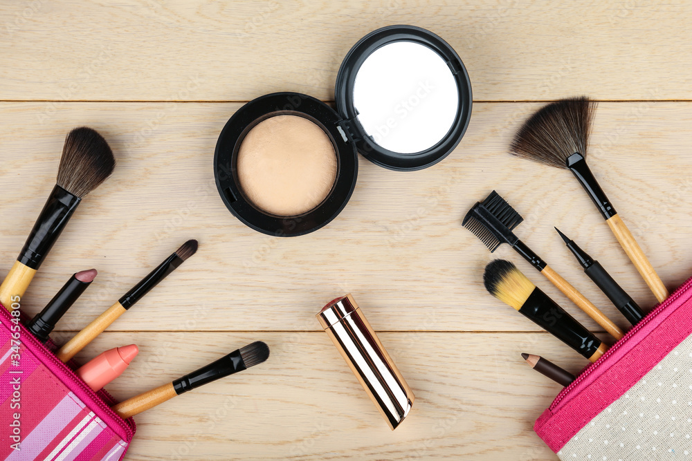 background with makeup brushes and products top view on light wooden surface background with makeup brushes and products top view on light wooden surface