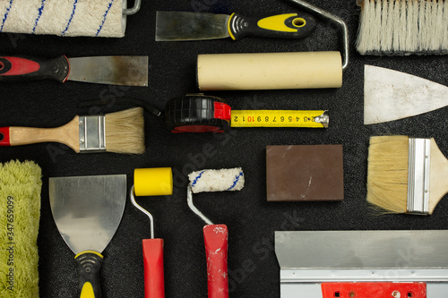 Set of house painter tools on black background, top view, flat lay