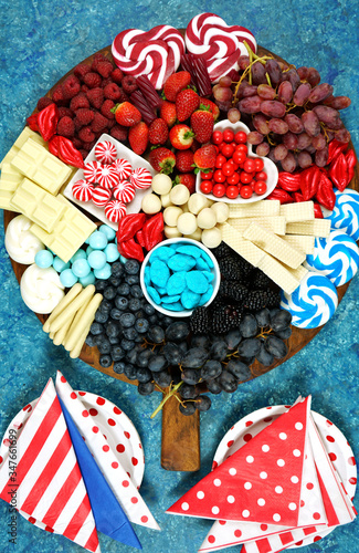 Patriotic charcuterie dessert grazing platter with fruit, chocolate and candy for independence and national holiday celebrations for countries that have a red white and blue flag. Vertical orientaion. photo