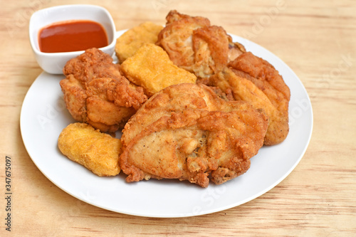 A plate of crispy fried chicken on a wood table