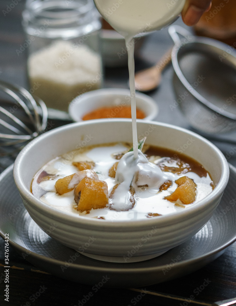 Pour coconut milk on the banana compote. Pour coconut milk on the banana compote.