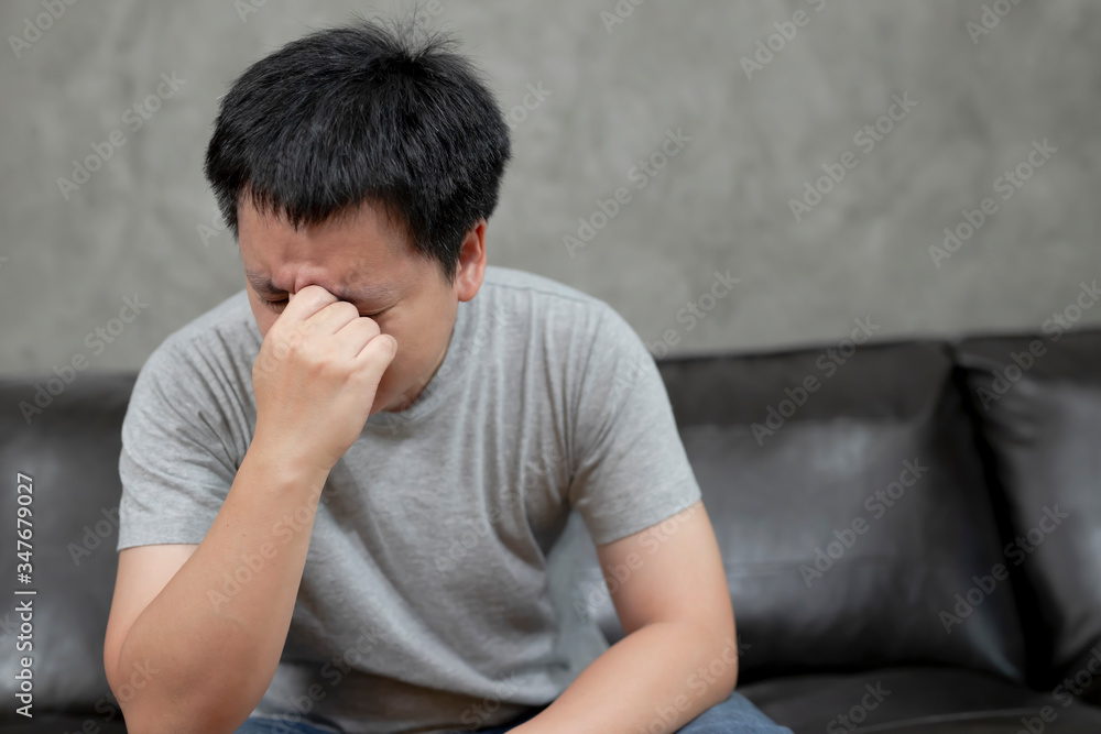 Young man is suffering from a headache,picture showing how much his head hurts,experiencing pain, looking miserable and exhausted,Concept healthcare and medical. Young man is suffering from a headache,picture showing how much his head hurts,experiencing pain, looking miserable and exhausted,Concept healthcare and medical.