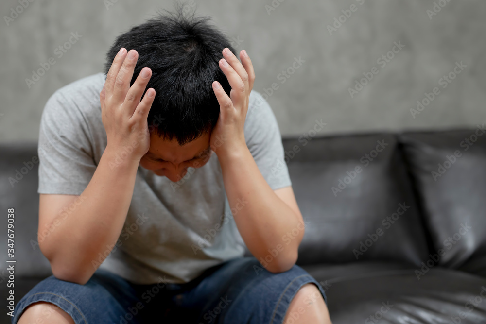 Young man is suffering from a headache,picture showing how much his head hurts,experiencing pain, looking miserable and exhausted,Concept healthcare and medical. Young man is suffering from a headache,picture showing how much his head hurts,experiencing pain, looking miserable and exhausted,Concept healthcare and medical.