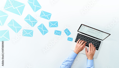 Business man sending and receiving email on white table. Using laptop for writing mail.