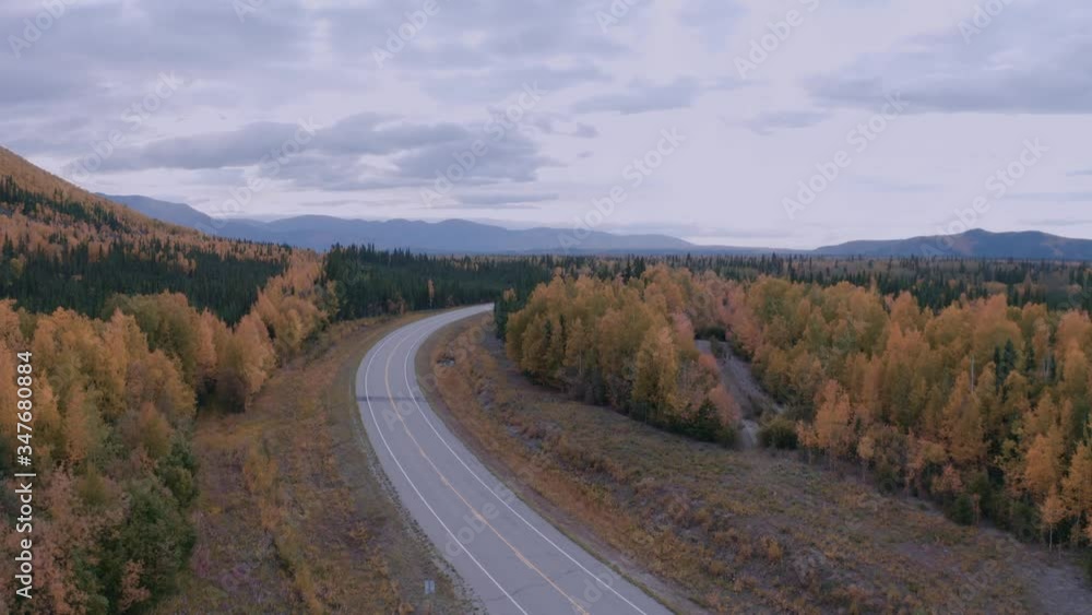 Rising Aerial Drone Shot of Highway in Wild Forest trees in Mountains on Fall Day in Alaska Rising Aerial Drone Shot of Highway in Wild Forest trees in Mountains on Fall Day in Alaska