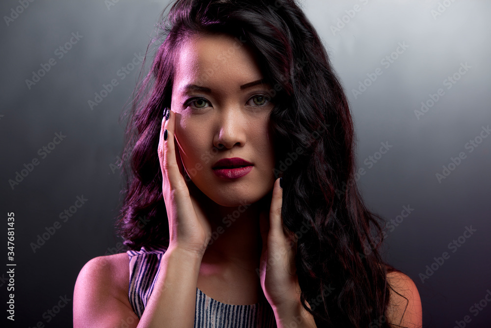 portrait of a beautiful asian woman with gold earrings and red lips being happy and posing in isolated background. she long black hair and smooth clean skin portrait of a beautiful asian woman with gold earrings and red lips being happy and posing in isolated background. she long black hair and smooth clean skin