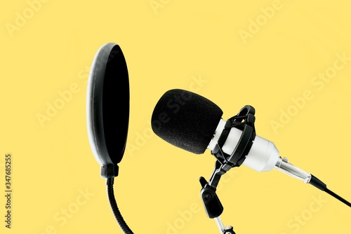 Podcast microphone on yellow background. 