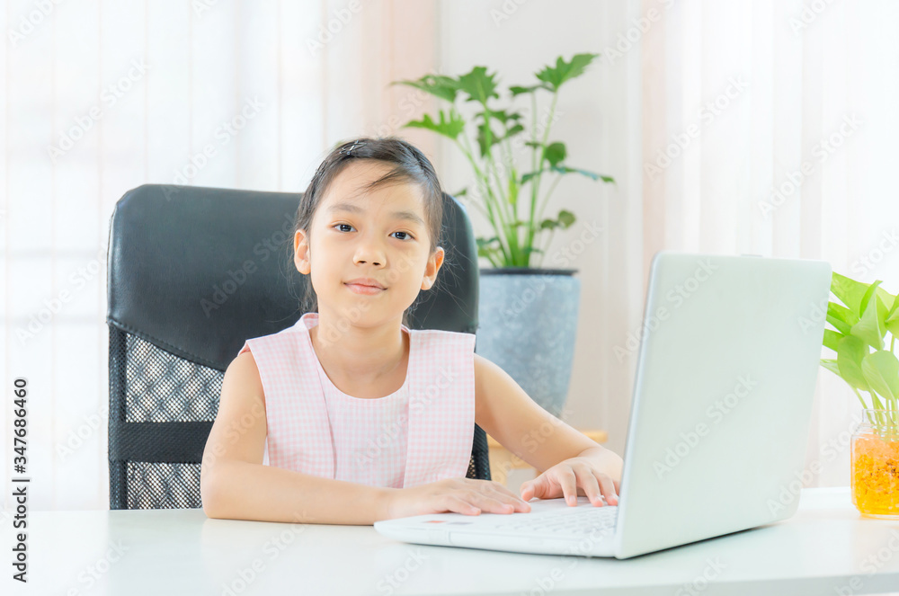 Cheerful little girl smiling and looking at camera with joy, Happiness and Learn from home concept Cheerful little girl smiling and looking at camera with joy, Happiness and Learn from home concept