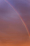 Rainbow in a dramatic sunset sky. Great scenery. Space for text. Background. Blurred. Vertical.